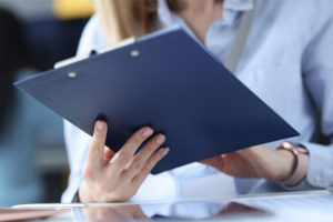 Doctor assesses patient while holding clipboard